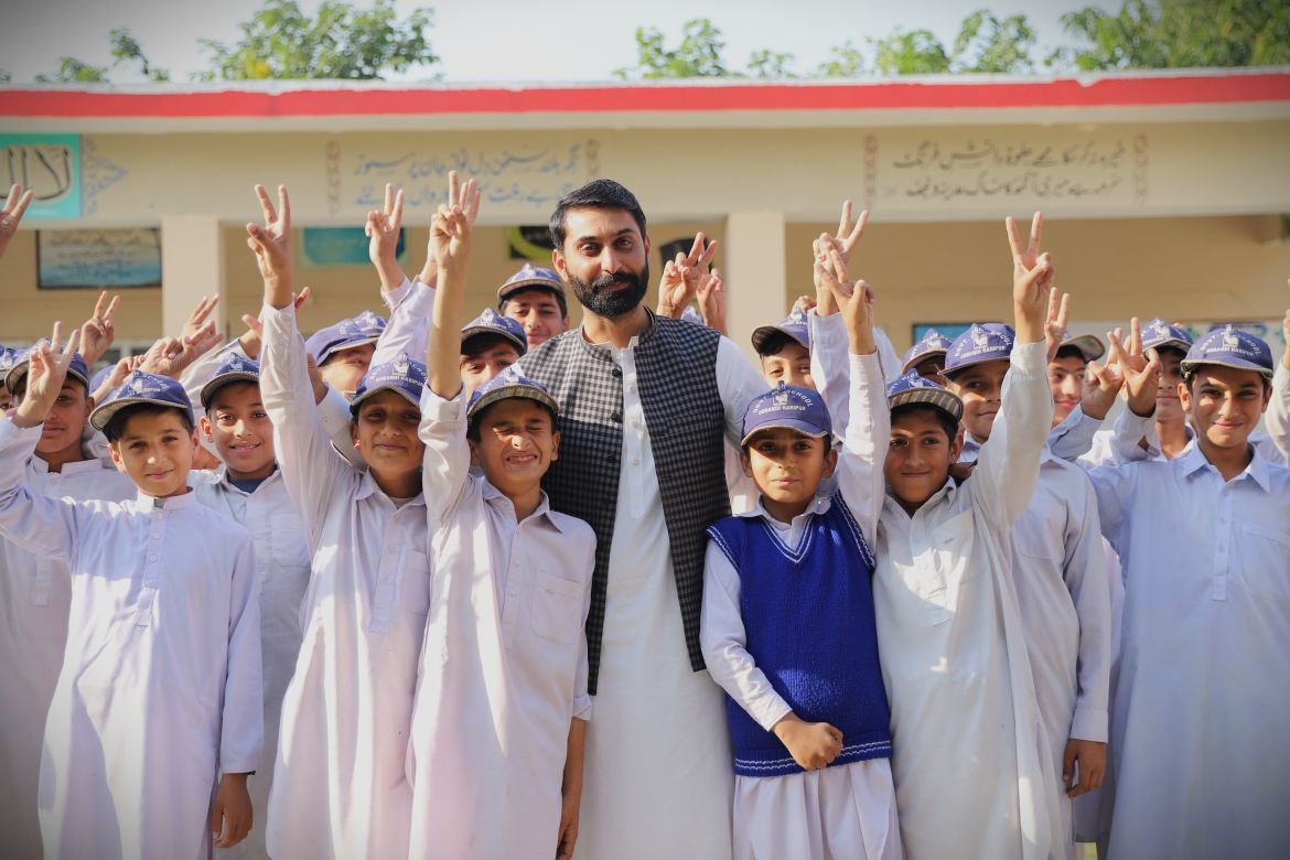 Muhammad Farooq Khan, a teacher at Government High School Dobandi in Haripur, Khyber Pakhtunkhwa, stands with Muzzamil and his fellow students. Credit: UNICEF/Pakistan/2025/Roham
